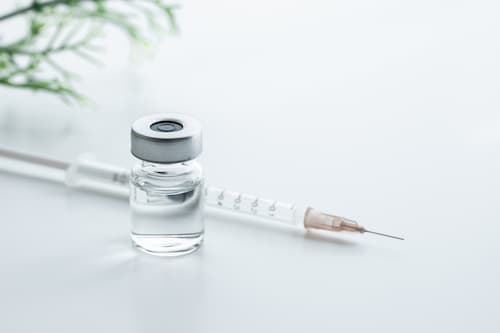 A syringe with the medication next to it.